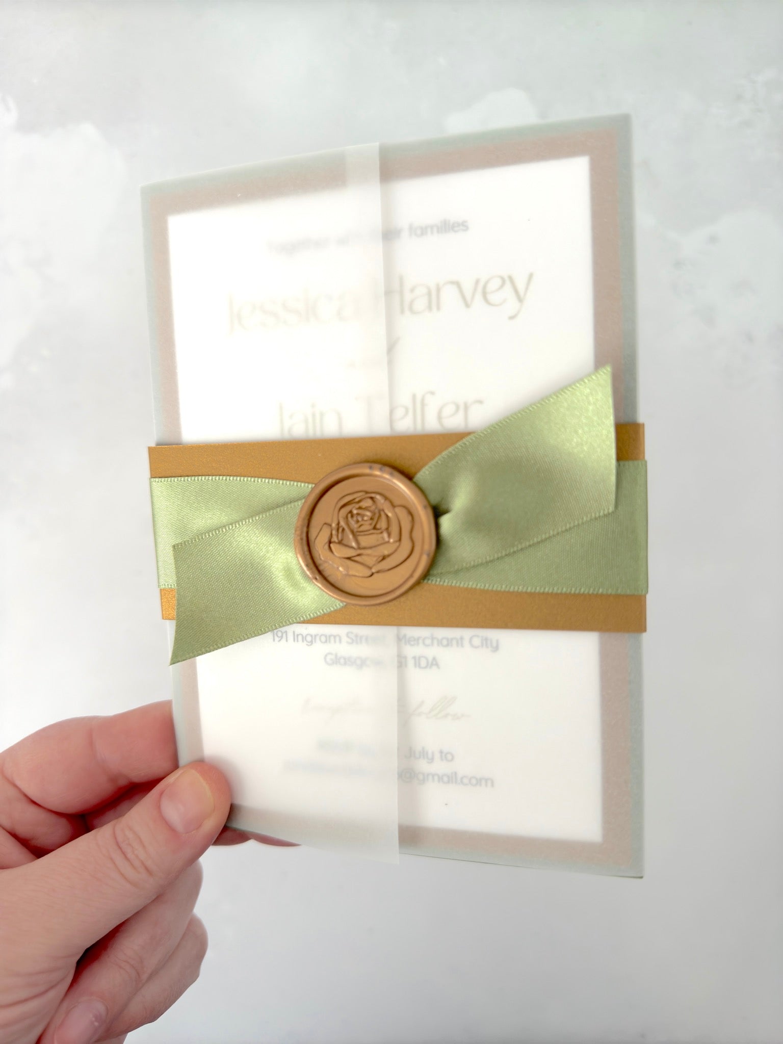 Lyn vellum sleeve wedding invitation with gold belly band wax seal and sage green satin ribbon