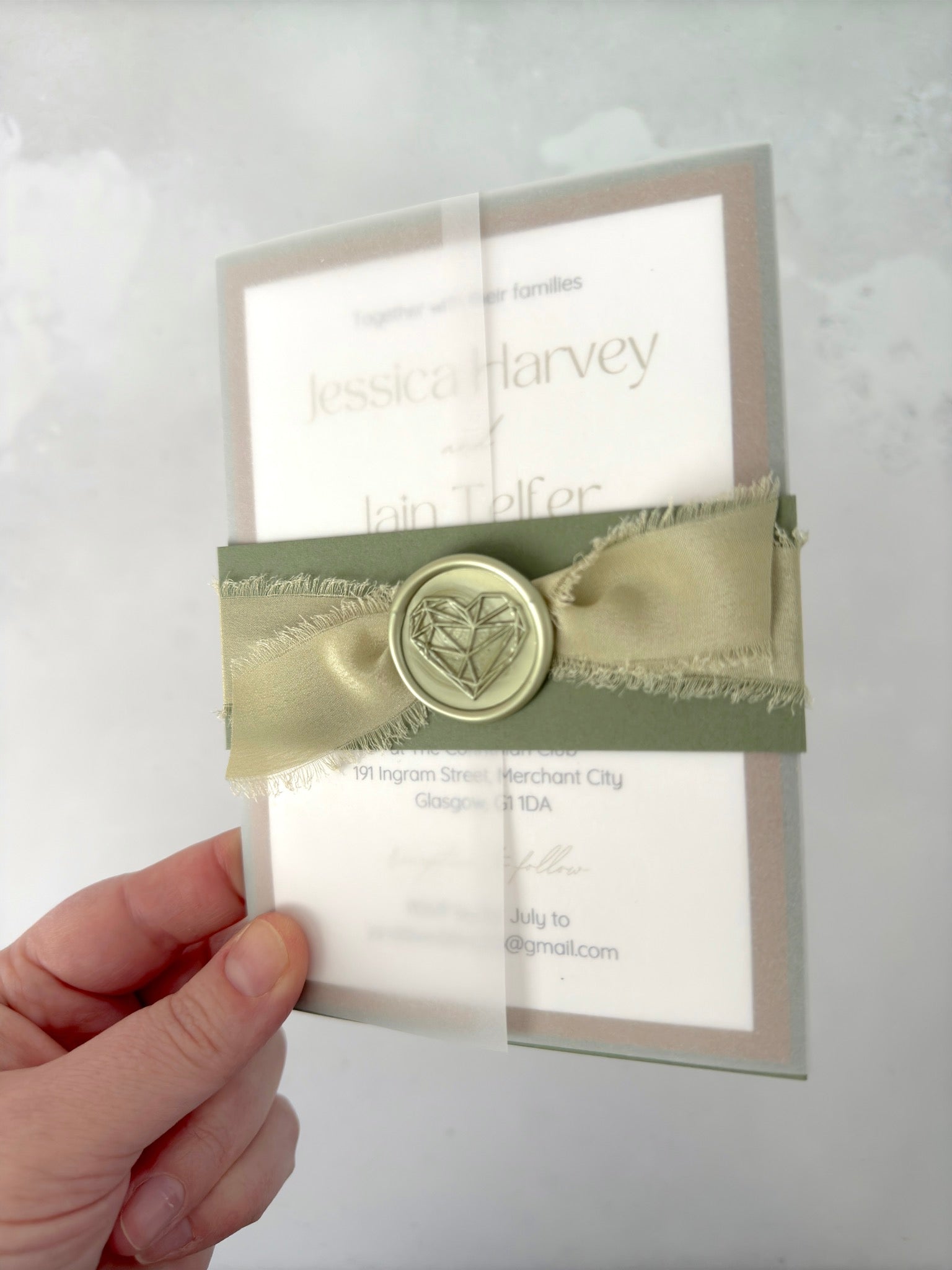 Lyn vellum wrap wedding invite with sage green silk ribbon and wax seal belly band