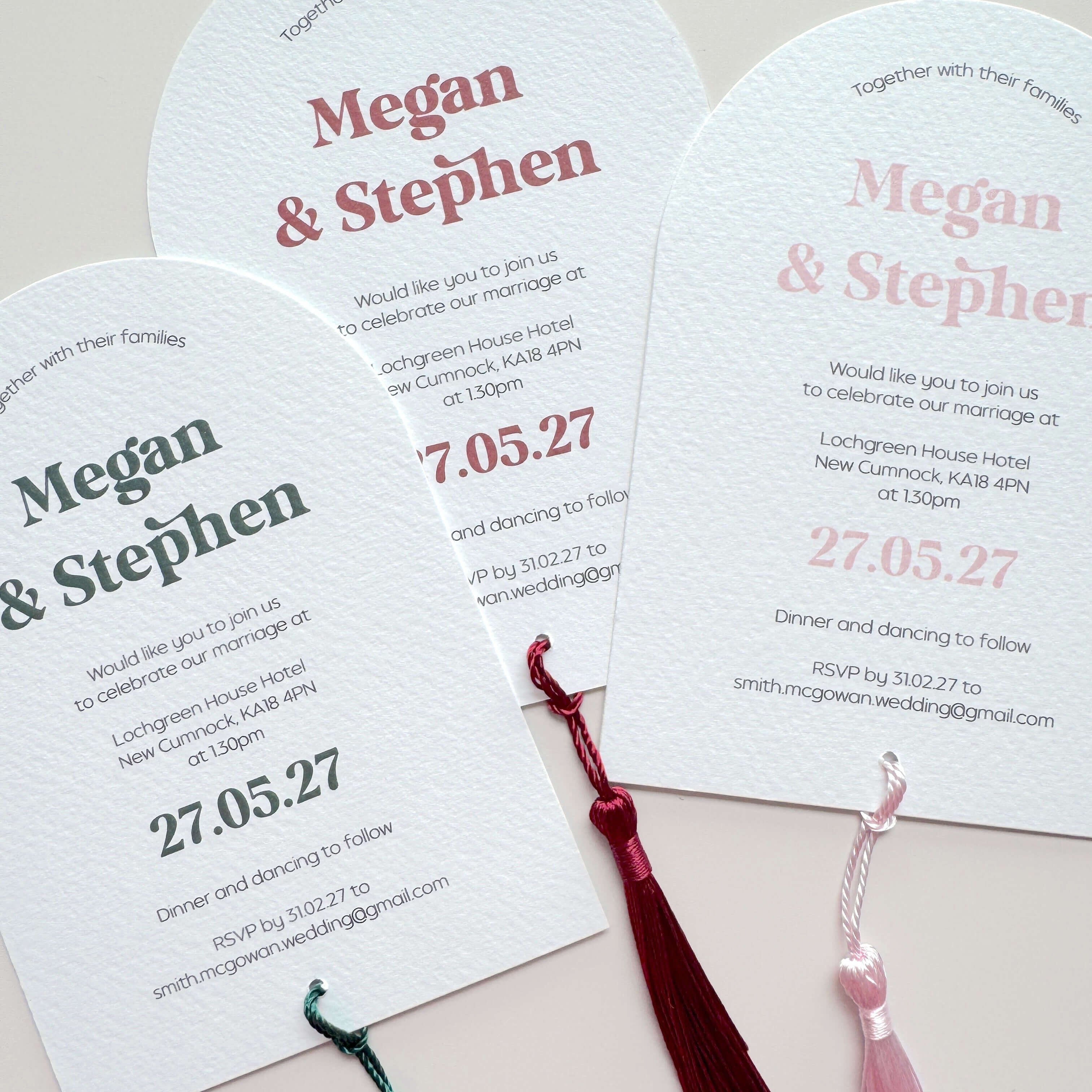 Three arch shaped textured white wedding invitations  with tassels 