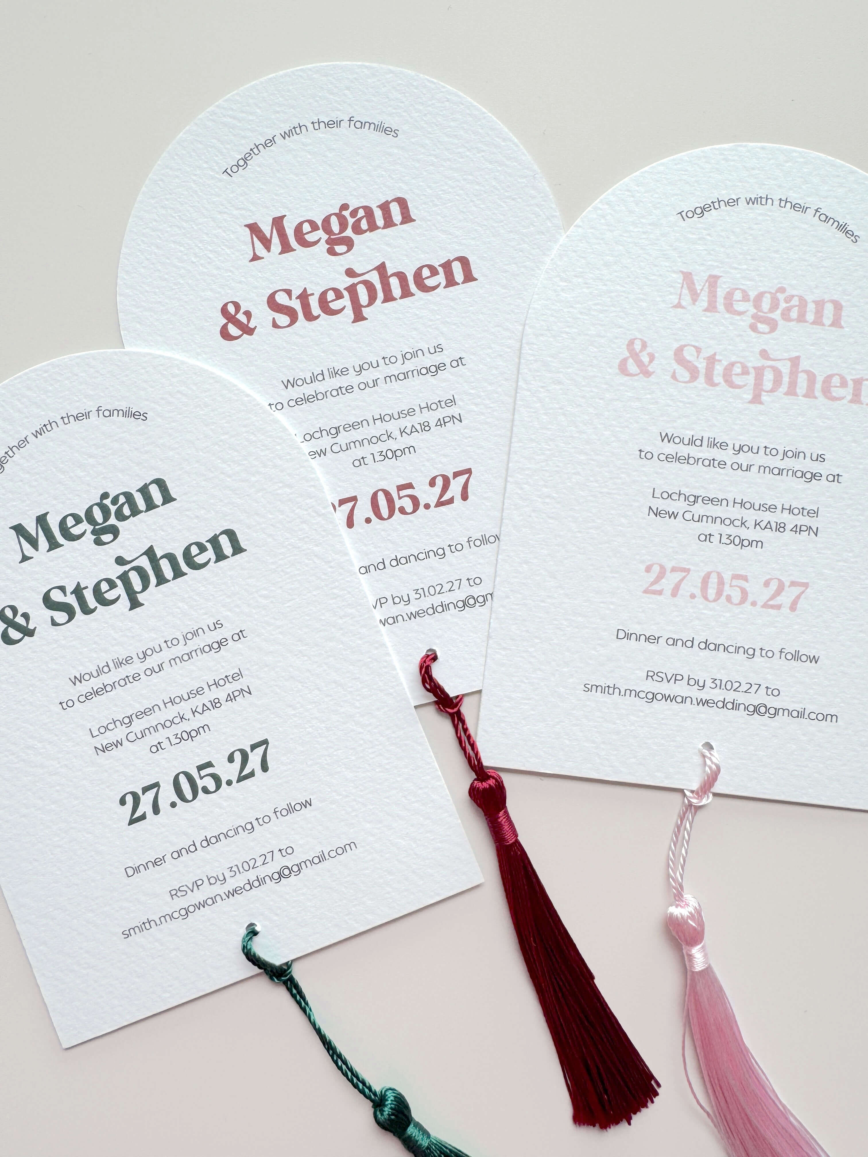 Three arch shaped textured white wedding invitations  with tassels 