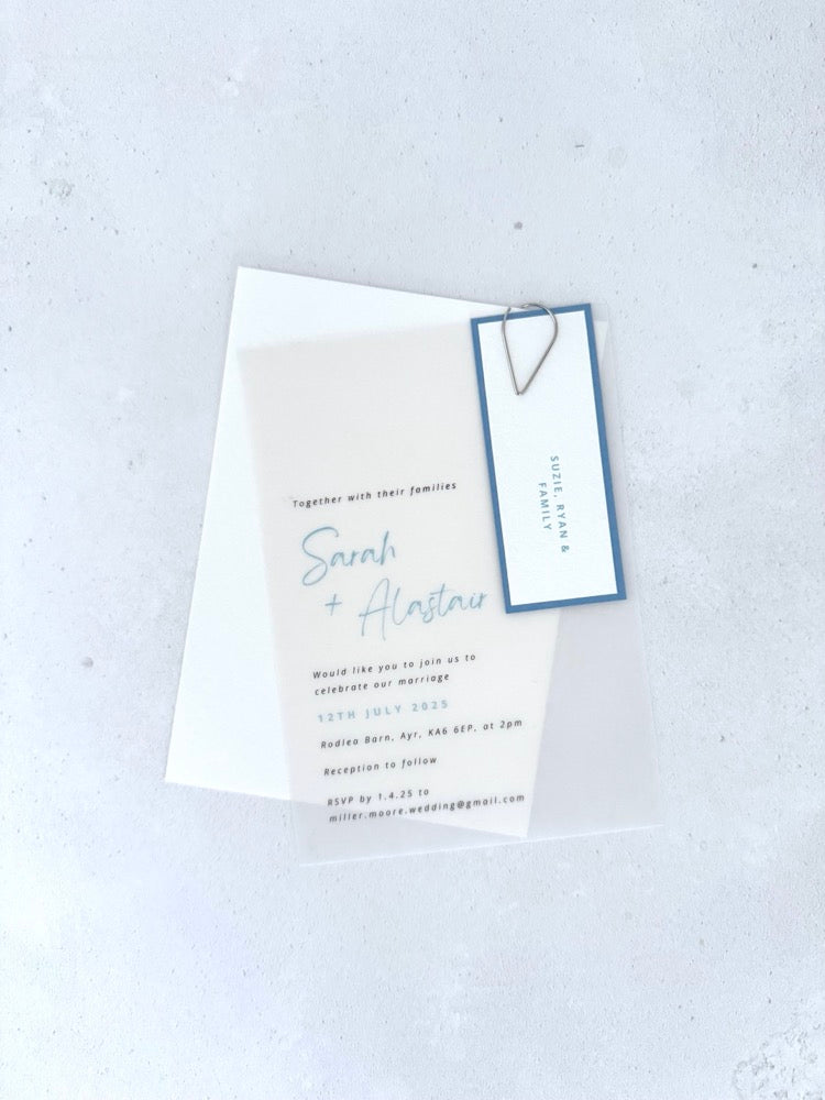 Sarah transparent vellum wedding invite with dusky blue name tag and silver teardrop paperclip 