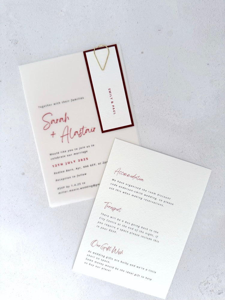 Vellum wedding invite with burgundy name tag and paperclip, with details card for wedding info and gift wish