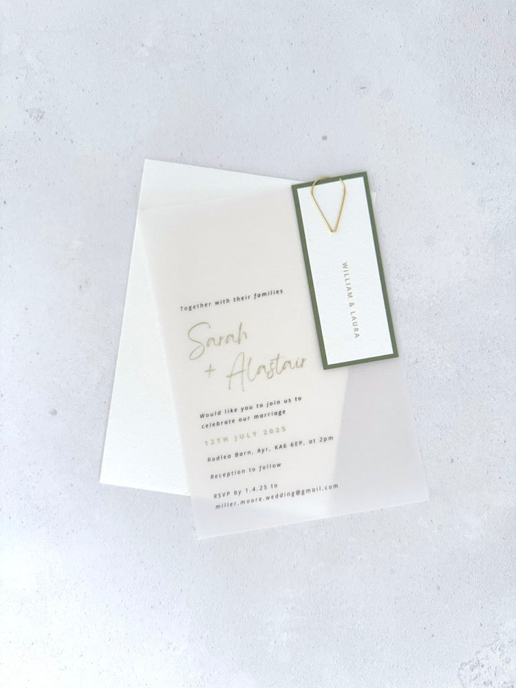 transparent vellum wedding invite with sage green guest name tag and gold teardrop paperclip and details card