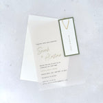 transparent vellum wedding invite with sage green guest name tag and gold teardrop paperclip and details card