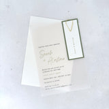 transparent vellum wedding invite with sage green guest name tag and gold teardrop paperclip and details card