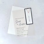 transparent vellum wedding invite with navy name tag and rose gold teardrop paperclip