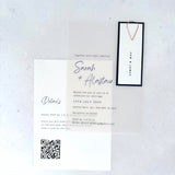 transparent vellum wedding invite with navy name tag and teardrop paperclip and details card with QR code
