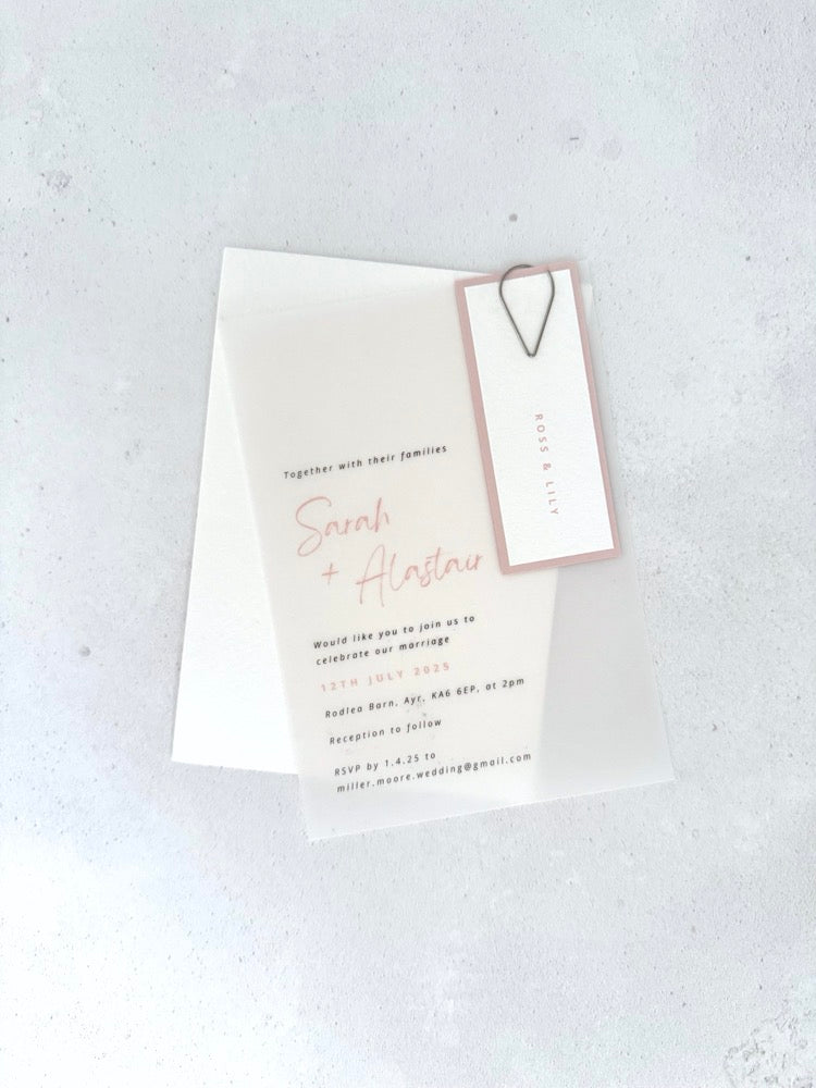 Sarah transparent vellum wedding invite with pink name tag and teardrop paperclip 